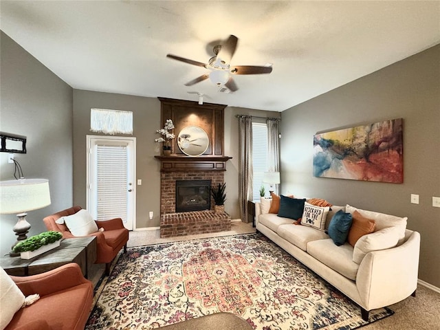 carpeted living room with ceiling fan and a fireplace