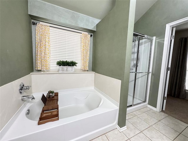 bathroom featuring independent shower and bath, lofted ceiling, and tile patterned floors