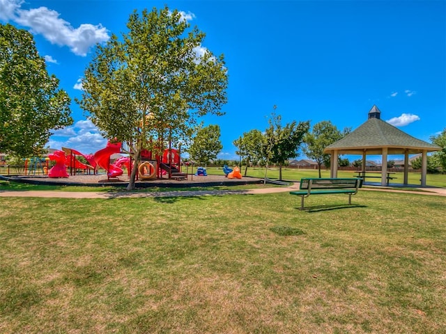 surrounding community featuring a playground, a gazebo, and a yard