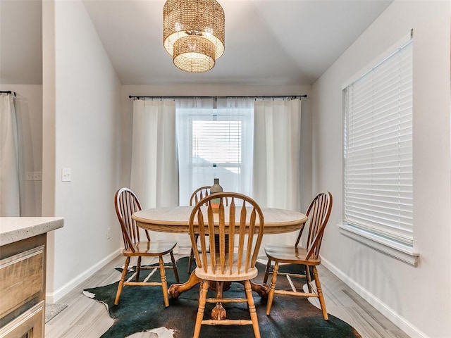 dining room with light hardwood / wood-style flooring and an inviting chandelier