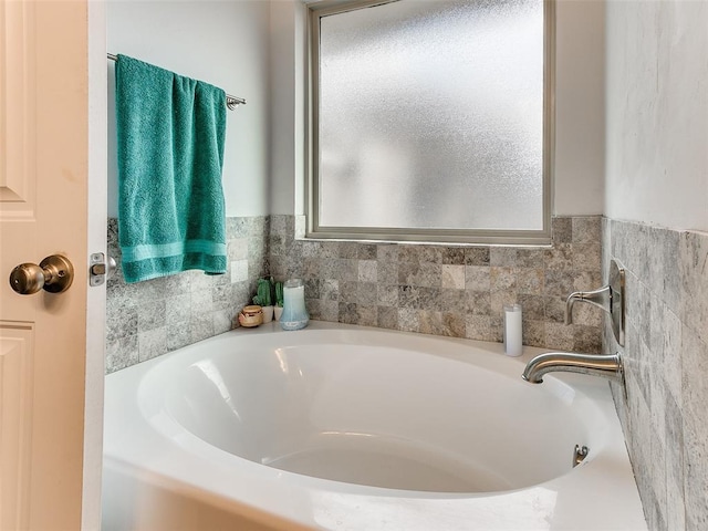 bathroom featuring a tub to relax in and tile walls