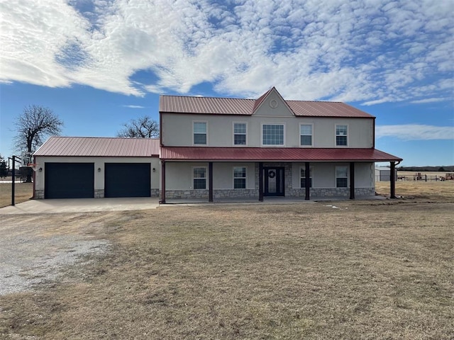 view of front of property featuring a garage, a front yard, and a porch