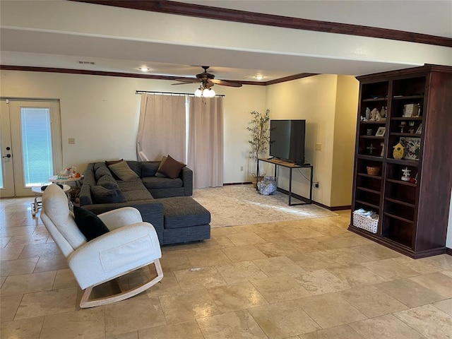 living area with stone tile flooring, crown molding, baseboards, and ceiling fan