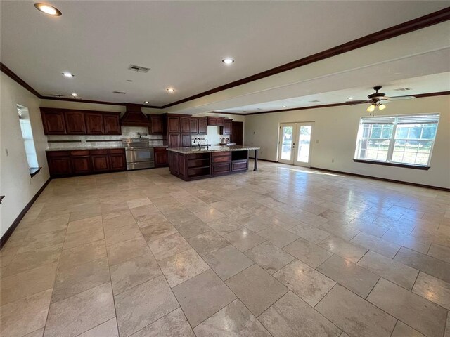 kitchen with crown molding, stainless steel electric stove, custom range hood, baseboards, and visible vents