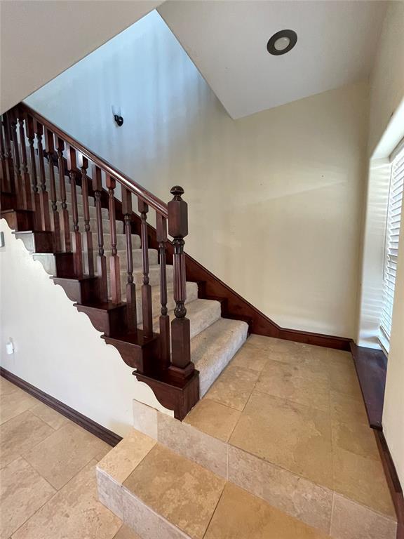 stairs with baseboards and stone finish floor