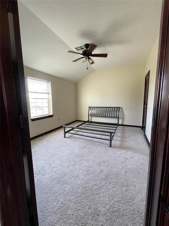 unfurnished bedroom with a ceiling fan, baseboards, lofted ceiling, and carpet