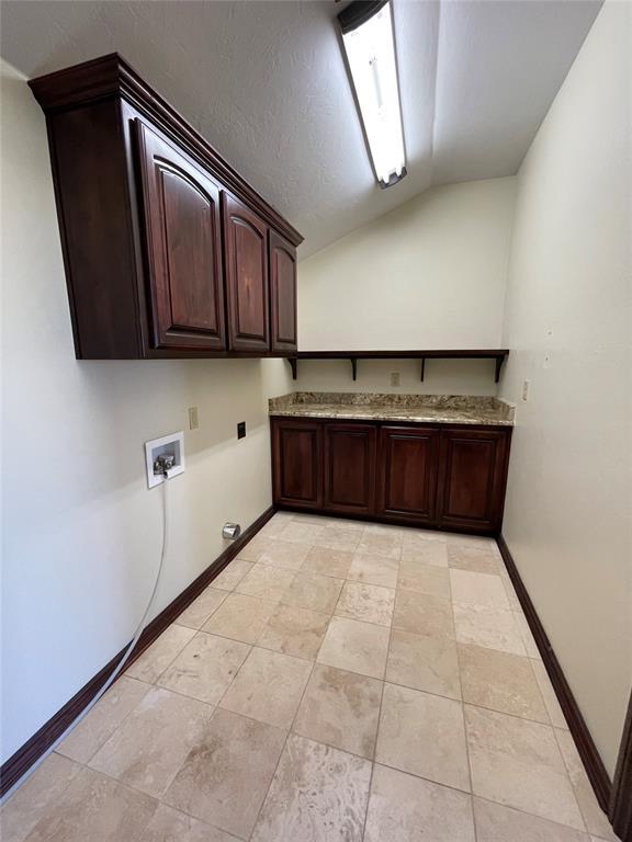 laundry area with baseboards, cabinet space, and washer hookup