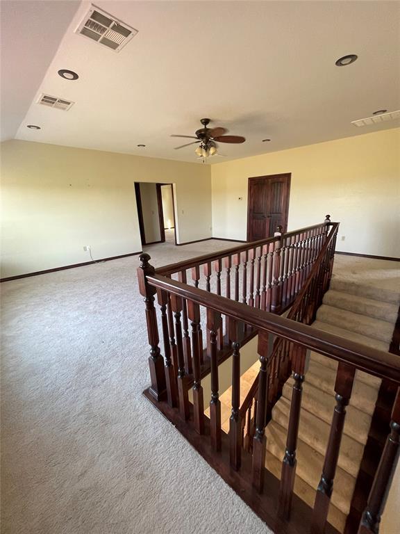 stairs with carpet, visible vents, and baseboards