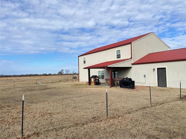back of property with fence and metal roof