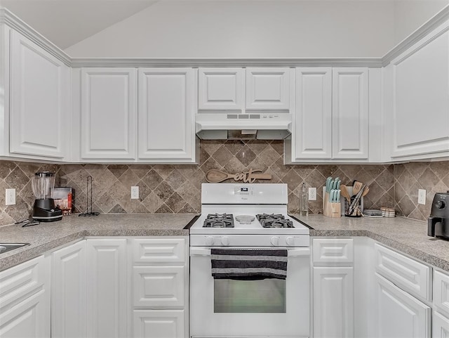 kitchen with white cabinetry, vaulted ceiling, decorative backsplash, and white gas range oven