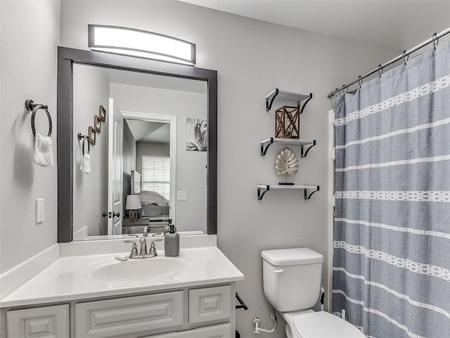 bathroom featuring vanity, walk in shower, and toilet