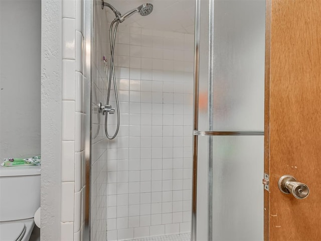 bathroom featuring an enclosed shower and toilet