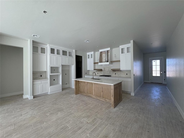 kitchen featuring white cabinetry, light hardwood / wood-style floors, and a spacious island