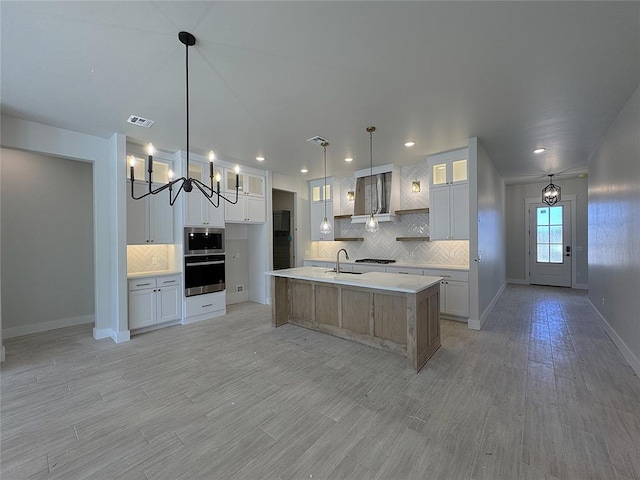 kitchen with visible vents, a sink, appliances with stainless steel finishes, an inviting chandelier, and light countertops