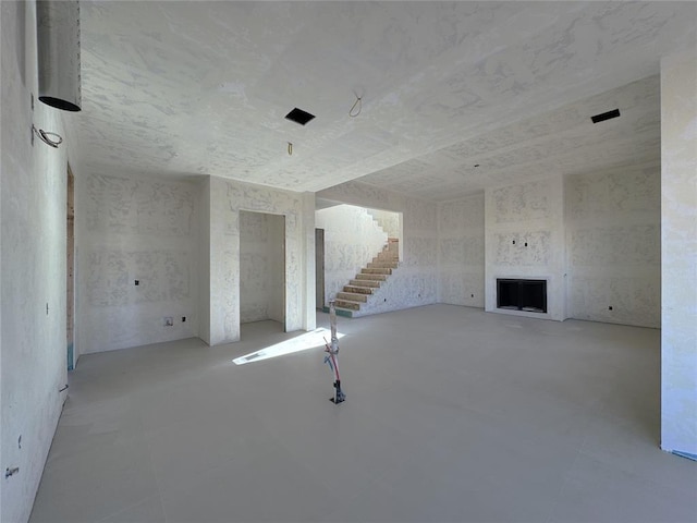 unfurnished living room with stairs and a fireplace