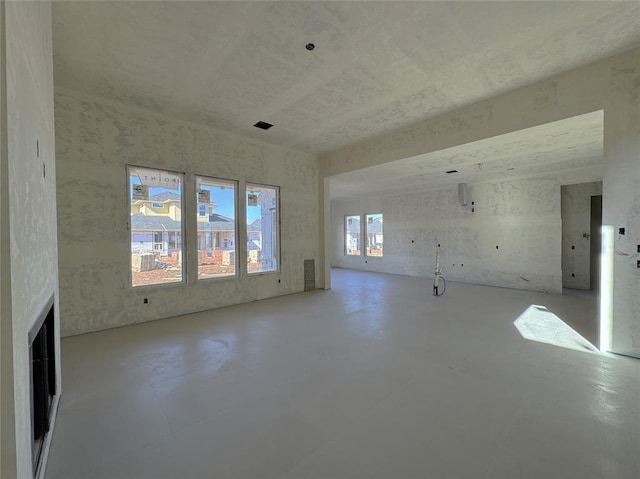 unfurnished living room featuring concrete flooring and a fireplace