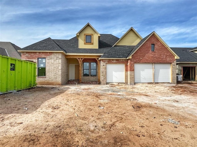 view of front of property with brick siding, driveway, and a shingled roof