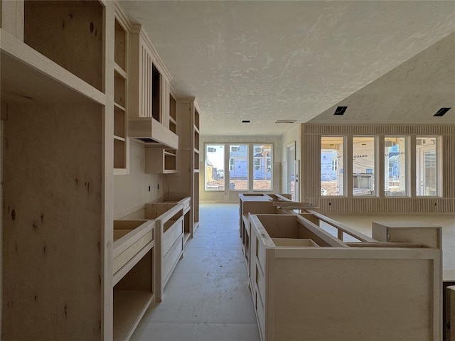 kitchen featuring a kitchen island, open shelves, and a textured ceiling