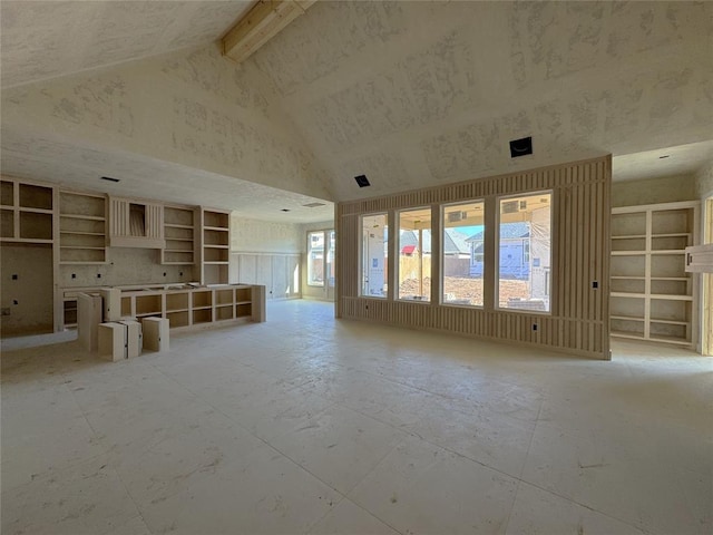 unfurnished living room with high vaulted ceiling