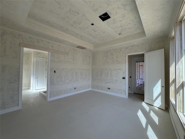 unfurnished room with a tray ceiling, baseboards, and wallpapered walls