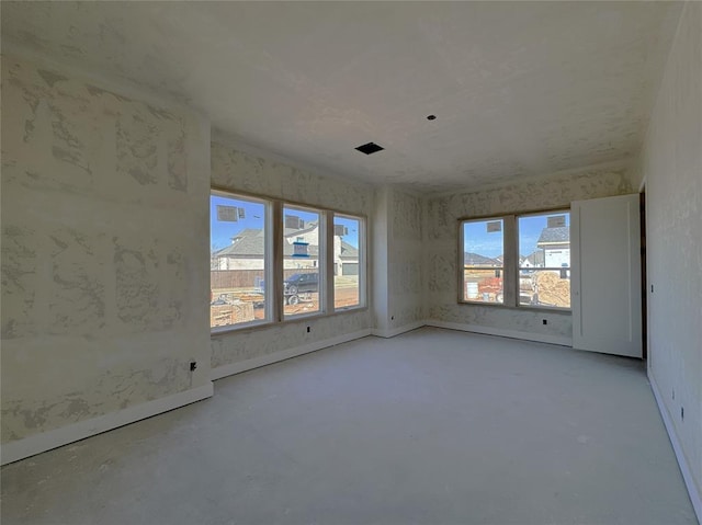 empty room featuring concrete flooring and baseboards