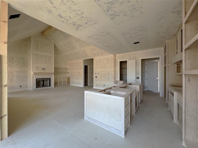 kitchen with lofted ceiling, a large fireplace, and open floor plan