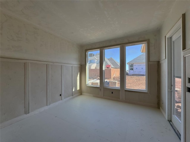 empty room with wainscoting and a decorative wall