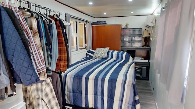 bedroom featuring a wall mounted AC and hardwood / wood-style flooring