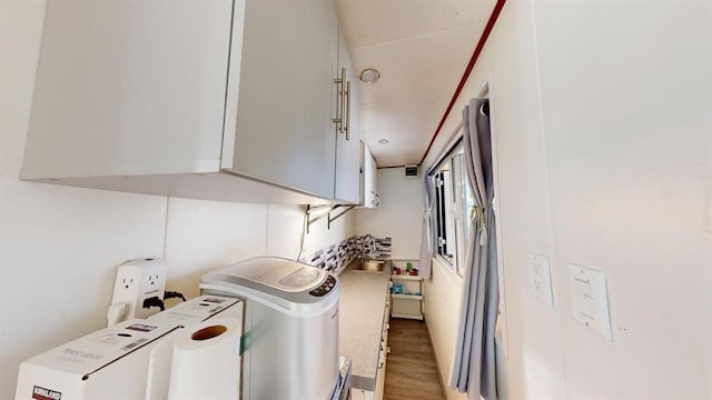 washroom with cabinets and wood-type flooring