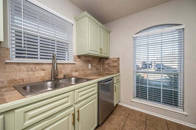 kitchen featuring dishwasher, sink, backsplash, light tile patterned floors, and green cabinetry