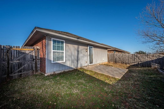 back of house with a patio area and a yard