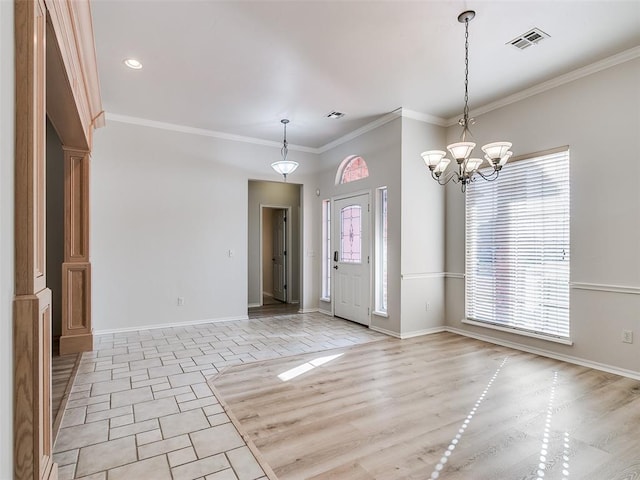 foyer with light hardwood / wood-style floors, crown molding, and an inviting chandelier