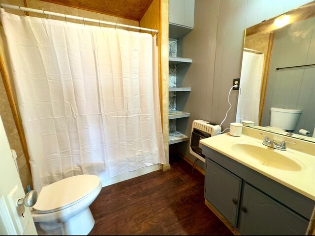 bathroom with vanity, toilet, wood walls, hardwood / wood-style flooring, and heating unit