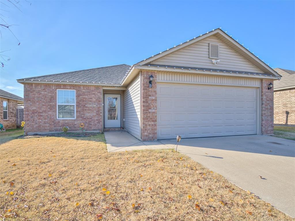 single story home featuring a garage and a front yard