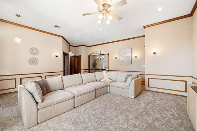 carpeted living room featuring ceiling fan, crown molding, and a textured ceiling