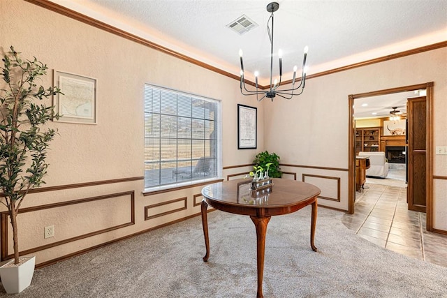 interior space with light carpet, a textured ceiling, a chandelier, and ornamental molding