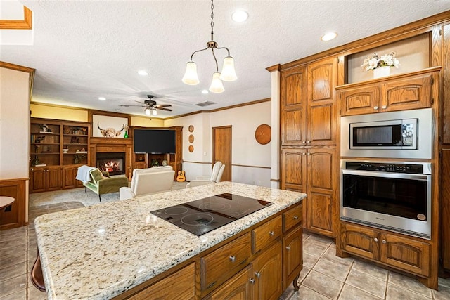 kitchen with hanging light fixtures, crown molding, a textured ceiling, appliances with stainless steel finishes, and a kitchen bar