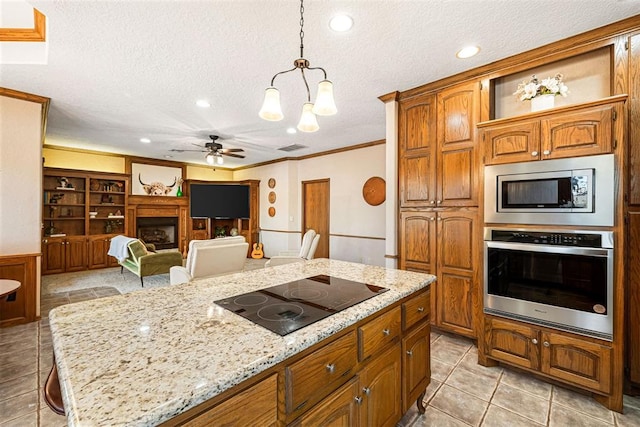 kitchen with a kitchen bar, a textured ceiling, stainless steel appliances, and hanging light fixtures