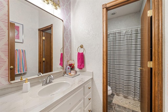 bathroom with tile patterned floors, vanity, toilet, and walk in shower