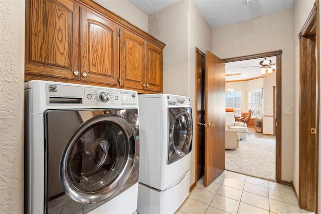 laundry area featuring cabinets, a textured ceiling, washing machine and dryer, and ceiling fan