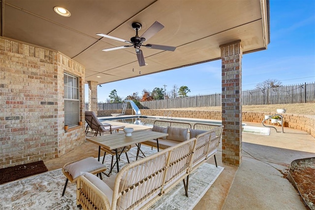 view of patio / terrace with a fenced in pool and ceiling fan