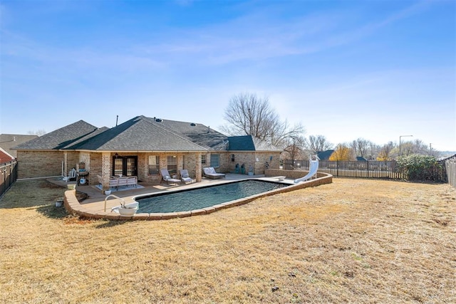 view of pool featuring a lawn, a patio area, and a water slide