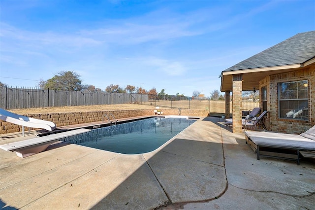 view of swimming pool featuring a patio, a diving board, and a water slide