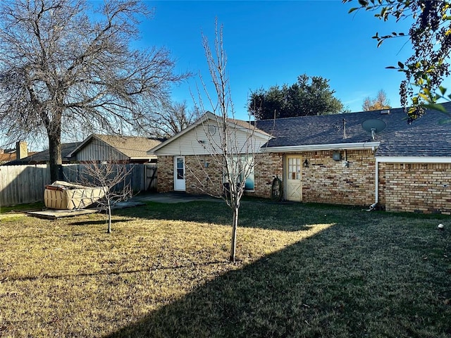 back of house featuring a lawn and a hot tub