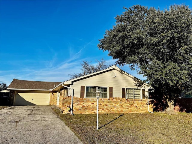 ranch-style house featuring a front yard and a garage