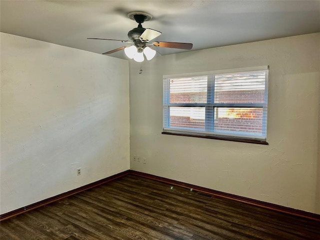 empty room with ceiling fan and dark hardwood / wood-style flooring