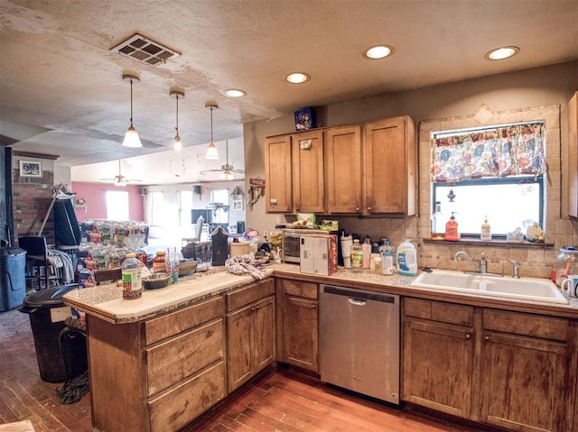 kitchen featuring dishwasher, decorative light fixtures, sink, and a wealth of natural light