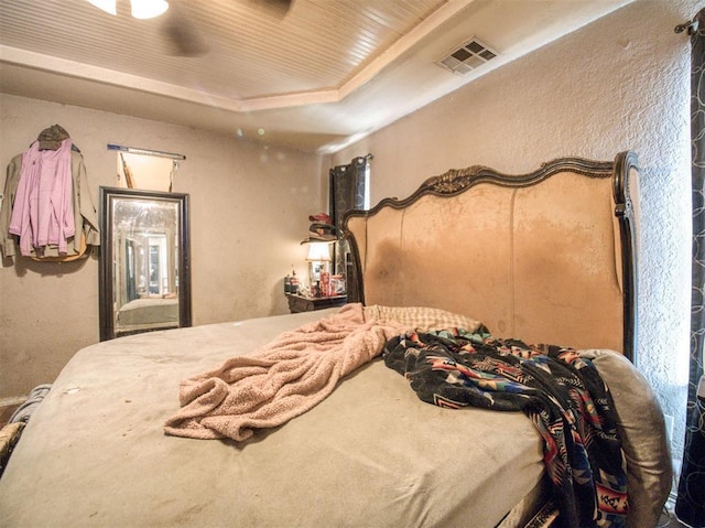 bedroom featuring a raised ceiling and ceiling fan