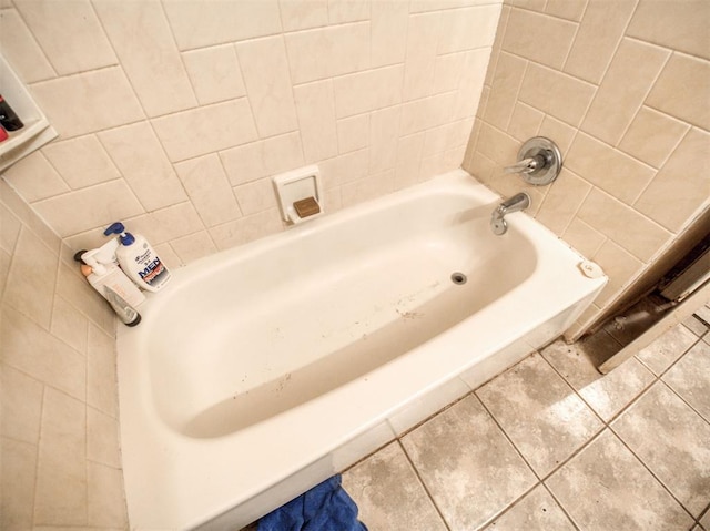 bathroom featuring a tub to relax in, tile patterned flooring, and tile walls