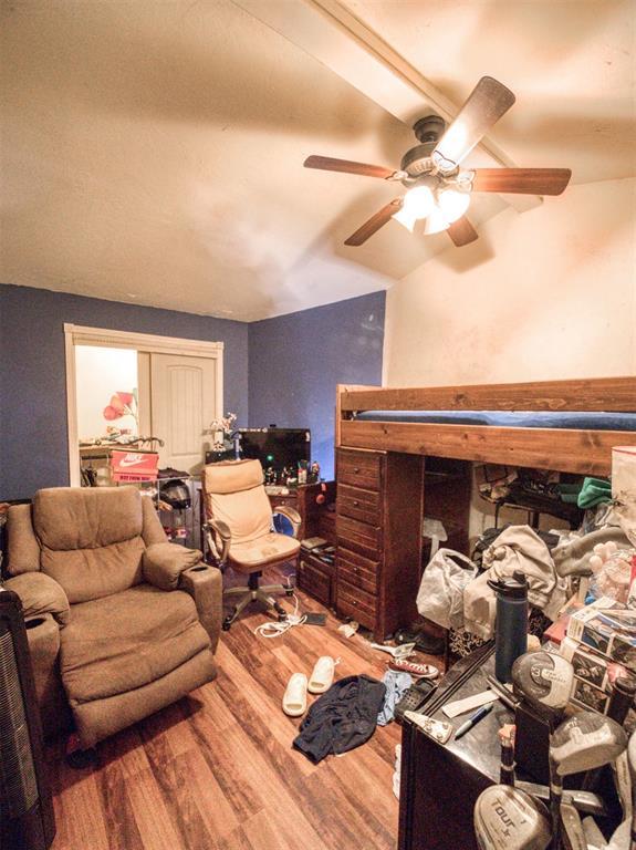 living room with ceiling fan, wood-type flooring, and vaulted ceiling